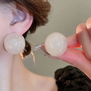 Detailed view of large ivory resin round stud earring with elegant pearl-like finish