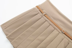 Dettaglio della gonna pantalone a pieghe kaki con texture vivaci e sottile cintura