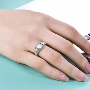Polished silver heart-shaped ring shown on hand with minimalist 18K gold stainless steel detail