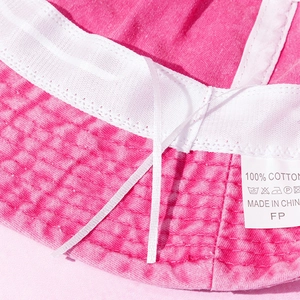 Macro detail of the rose red cotton bucket hat interior with adjustable drawstring strap