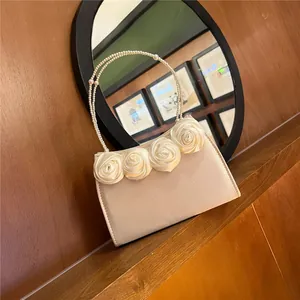 Detail of champagne satin evening bag with silk roses and pearl beaded handle