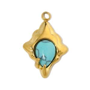 Macro shot of green malachite stone teardrop pendant in a gold fan-shaped steel base