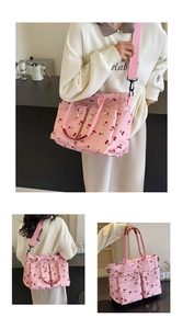 Detail view of pink cherry print tote with multi-pocket design and adjustable strap