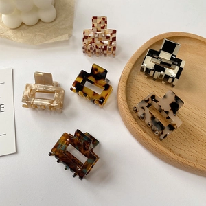 Mini acetate square hair claws with tortoiseshell and checkerboard patterns in a wood tray