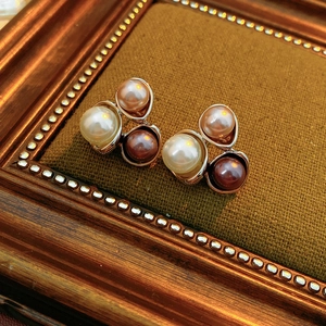 Boucles d'oreilles vintage en perles tricolores et zircons sur fond de velours marron