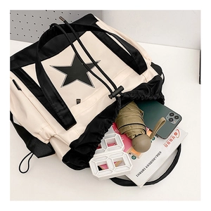 Detail of canvas messenger bag with star print showing spacious interior and drawstring