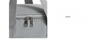 Detail of grey insulated lunch bag featuring smooth dual metal zippers and honeycomb texture