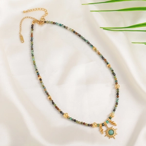 Bohemian colorful natural stone beaded necklace with a sun pendant on white silk fabric