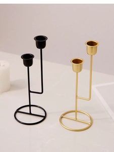 Detail of modern minimalist metal candle holders in elegant black and gold finishes
