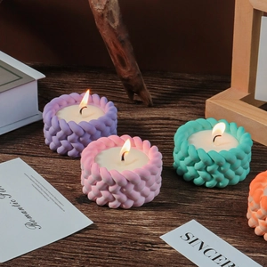 Lighted knit texture silicone candle molds in purple, pink, teal, and orange on wood