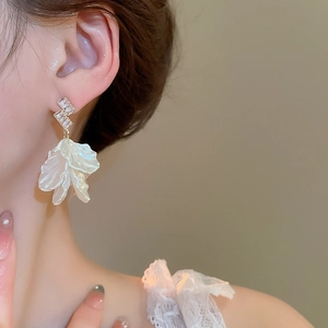 Detail of floral petal drop earring with sparkling zircon studs on female model