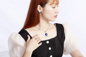 Parure de bijoux Main de Fatma en argent avec cristal bleu sur un modèle féminin