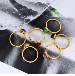Detailed view of polished 18K gold rings with colorful round natural stone cabochons