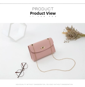 Détail d'un sac à bandoulière rectangulaire rose clair avec chaîne dorée et fermoir