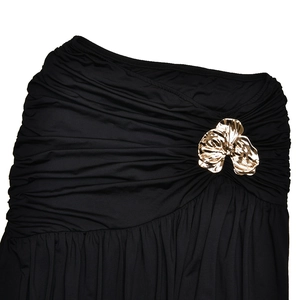 Detailed view of black pleated fabric featuring a luxury gold floral metal buckle ornament