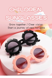 Close-up of flower shaped children's sunglasses in black and pink on a white stand