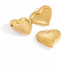Detailed close-up of a gold heart locket pendant featuring intricate floral embossing