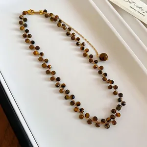 Collana con occhio di tigre sfaccettato e catena dorata vista da un angolo di 45 gradi