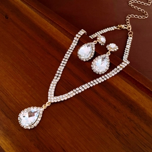 Dettaglio del set di gioielli con fiori a goccia di diamanti su sfondo in legno scuro