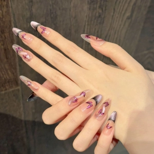 Détail d'ongles amande œil de chat avec motif papillon violet et paillettes brillantes