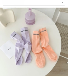 Detail view of cotton mid-calf socks featuring ribbed texture and letter pattern