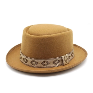 Close-up of camel wool felt hat featuring a vintage beige ribbon with brown diamond patterns