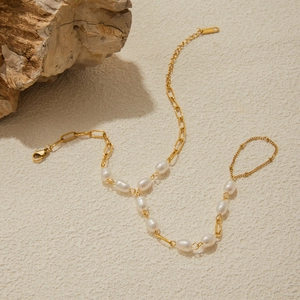 Dettaglio del bracciale ad anello dorato con perle d'acqua dolce e chiusura a moschettone