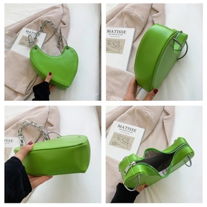 Detail view of grass green heart-shaped bag with silver chain and smooth PU leather