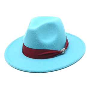 Detail of blue felt fedora with a dark red ribbon and sparkling rhinestone buckle