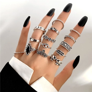 Close-up of gothic silver rings with moon, star, and evil eye details on model's hand