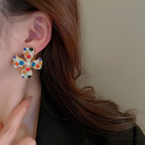 Close-up of pearl flower ear cuff with colorful rhinestones and gold-plated metal base