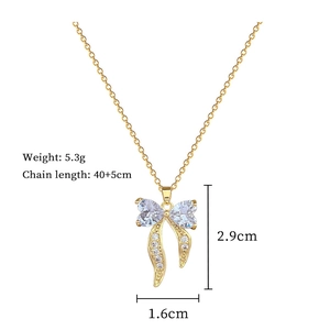 Detail of gold bow necklace with dimensions 2.9cm x 1.6cm and 5.3g weight display