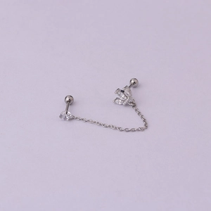 Detail view of double piercing chain earring with crown zircon and polished silver link