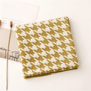 Macro view of soft houndstooth fabric texture in yellow and white for scarves