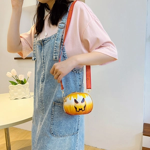 Model wearing a pumpkin-shaped crossbody bag with orange gradient and striped strap