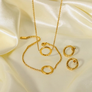 Minimalist gold-plated stainless steel jewelry set with hammered texture on silk fabric
