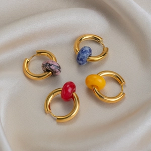 Detailed shot of gold hoop earrings with lapis lazuli and colorful stone pendants