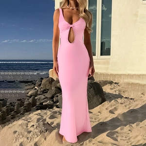 Robe longue rose moulante ajourée pour femme dans un décor de plage naturel