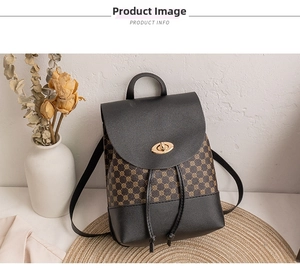 Detail of vintage geometric pattern backpack with gold twist lock on woven mat