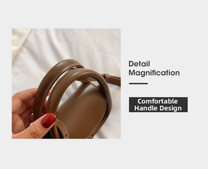 Détail zoomé sur les poignées cylindriques confortables du sac à main en cuir marron