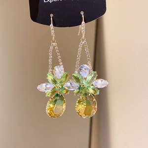 Detailed macro view of vintage ethnic drop earrings with green crystals and gold plating