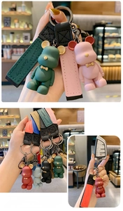 Detail of colorful bow-tie bear keychains featuring matte texture and stitched leather straps