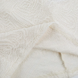 Macro shot of intricate white lace embroidery and texture on a mini evening dress