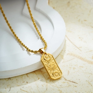 Macro view of 18K gold square evil eye pendant with star and moon on a twist chain