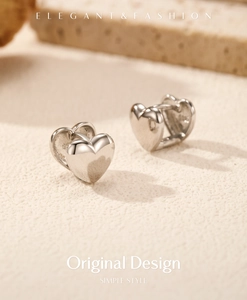 Vue macro de boucles d'oreilles cœur en argent 925 avec finition miroir polie