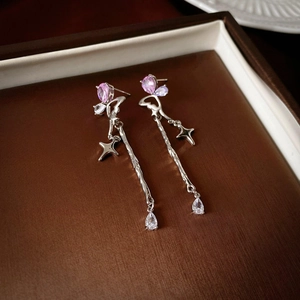 Detail of silver flower star earrings with pink zircon droplets and long chain tassels
