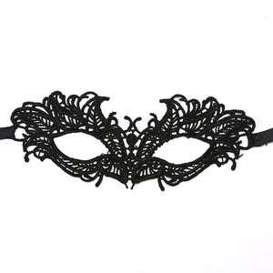 Detailed close-up of intricate black lace masquerade mask with symmetrical floral patterns