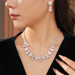 Close-up of model wearing pink floral zircon necklace and earrings in silver setting