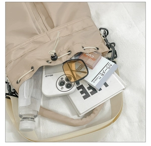 Bovenaanzicht van beige nylon emmertas met ruime binnenkant voor dagelijkse spullen
