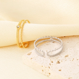 Detailed close-up of French vintage gold and silver open rings on silk fabric background